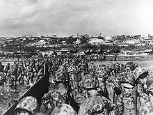 1945年4月1日，美国海军陆战队员涉水上岸支援冲绳岛滩头。