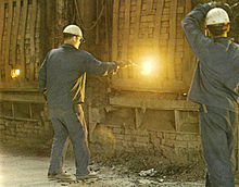 Deze arbeiders controleren de oven in een staalfabriek. De oven verspreidt rook, dampen en kleine deeltjes. Dit zijn irriterende stoffen en ze kunnen werkgerelateerde astma veroorzaken of uitlokken.  