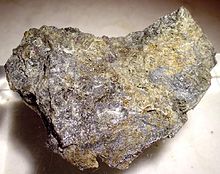 Små klumpar av flytande kvicksilver som ett element tillsammans med strimmor av cinnober.  