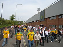 Kibice idący wzdłuż drogi, po której stadion bierze swoją nazwę