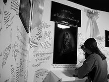 Uma jovem assina um muro de oração por Holloway, menos de duas semanas após seu desaparecimento.