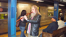 Een Indiaanse fluitspeler treedt op voor donaties in een treinstation in New York City.  