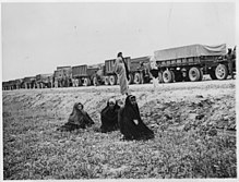 Women looking at an Allied supply convoy for the USSR on the "Persian Corridor", somewhere between Tehran and Bandar Pahlawi, June 1943 (today's name: Bandar Anzali).