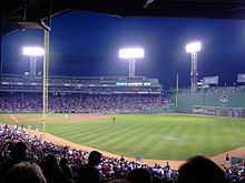 Un partido nocturno en Fenway Park, un parque de béisbol estadounidense en Boston, Massachusetts.  