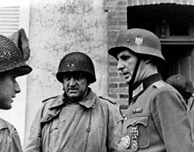 A German army officer talking with two U.S. officers in Cherbourg after the surrender