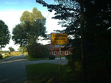 Silniční značka v severním Německu, německý název je Elmlichheim, dolnosaský Emelkap. Elmlichheim leží na hranici s Nizozemskem, na německé straně.