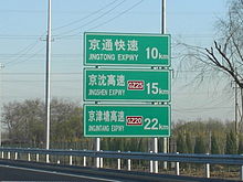 Panneau routier sur une autoroute chinoise près de Pékin. Le panneau utilise le symbole international "km" pour "kilomètres".