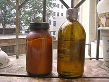 Het flesje links is fosfor(V) chloride  