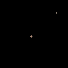 Pluto and Charon orbit each other (graphic). The barycenter ­(white dot in the middle) lies outside of Pluto.