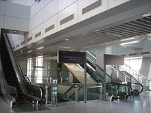 Nivel del vestíbulo de la estación de MRT/LRT de Punggol, con escaleras mecánicas que conducen al andén del LRT.  