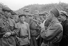 Um comandante guerrilheiro ensinando seus combatentes a usar armas, perto de Smolensk, em 1941