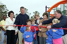 Brett Favre, tercero por la izquierda; su esposa Deanna, segunda por la izquierda; y la Primera Dama Laura Bush, tercera por la derecha; asisten a una ceremonia de corte de cinta en Kiln, Mississippi, tras el huracán Katrina.