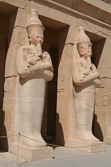 Osirische beelden van Hatsjepsoet bij haar graftombe, één bij elke pilaar. Let op de mummificatie lijkwade die het onderlichaam en de benen omhult en de kromstaf en vlegel die in verband worden gebracht met Osiris-Deir el-Bahri