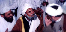 Shahi vid ett evenemang i Imam Bargah-e-Noor-e-Iman-moskén i Karachi, Pakistan. Här talar han med två religiösa präster från olika sekter inom islam: Shia-islam och Sunni-islam.