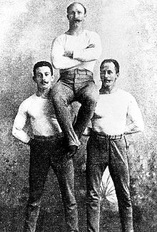 Os campeões individuais alemães da ginástica: Schuhmann, Flatow, e Weingärtner