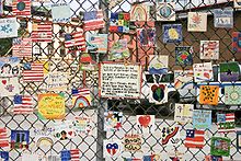 Ar rokām apgleznotu flīžu sērija, kas veltīta 11. septembra uzbrukumu upuriem, uz automašīnu stāvlaukuma žoga Ņujorkā.