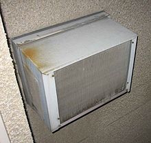 A seção externa de uma unidade genérica de ar condicionado de uma sala. Para facilidade de instalação, as unidades são normalmente instaladas em janelas ou, como nesta fotografia, um furo na parede