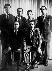 The six members of the FLN's collective leadership before the start of the revolution they commanded on November 1, 1954; back row from left to right: Rabah Bitat, Mostefa Ben Boulaïd, Didouche Mourad, Mohammed Boudiaf; seated from left to right: Belkacem Krim, Larbi Ben M'Hidi.