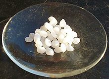 Natriumhydroxidpellets på en glasskål.