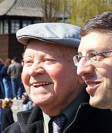 Henryk Mandelbaum och en tolk samtalar på platsen för krematorierna i Birkenau. Han var medlem av lägrets Sonderkommandos.  