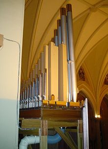 Achteraanzicht van een orgel met metalen en houten pijpen.
