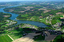Highly diverse cultural landscape in a rural region of North Rhine-Westphalia, the most densely populated state in terms of surface area: settlements, agriculturally used areas, wooded areas and a reservoir.