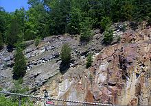 Górna skośna warstwa szarego dolomitu ma około 500 milionów lat. Czerwonawy ryolit, na którym spoczywa dolomit, ma około 1,5 miliarda lat. Na tym zdjęciu brakuje miliarda lat historii geologicznej. Missouri Ozarks.
