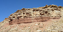 Maritime Randsequenz der mittleren Trias aus Schluffsteinen (rötliche Schichten an der Klippenbasis) und Kalksteinen (braune Felsen darüber), Virgin Formation, südwestliches Utah