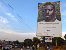 Um cartaz de campanha contra a violência doméstica em Uganda. O cartaz diz: Bater na minha esposa destruiu meu casamento, não faça o que eu fiz.
