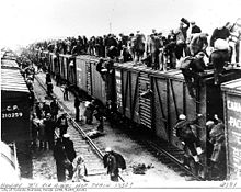 Unemployed migrant workers (hoboes) jump on a freight train to look for work in other cities