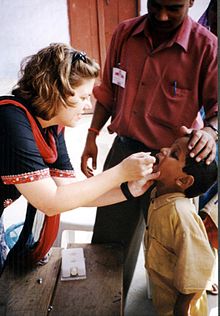 Uma criança na Índia está sendo vacinada contra a poliomielite.