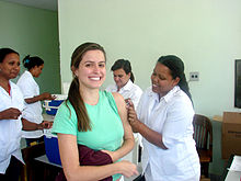 Rokotuksilla voidaan ehkäistä monia vertikaalisesti tarttuvia infektioita. Tämä nainen rokotetaan vihurirokkoa vastaan (Brasilia, 2008).  