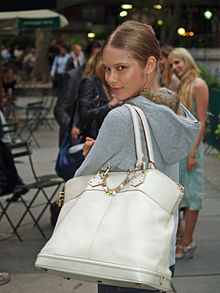 Model op de New York Fashion Week die een Louis Vuitton handtas showt.
