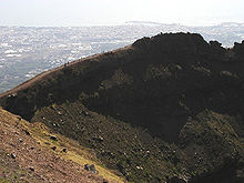 Een blik op de kratermuur van de Vesuvius, met op de achtergrond de stad Torre del Greco