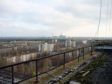 チェルノブイリ原発事故後、廃墟となったウクライナのプリピャート市。背景に見えるのはチェルノブイリ原子力発電所。