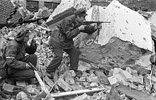 Henryk Ożarek "Henio" (à gauche) et Tadeusz Przybyszewski "Roma" (à droite) de la compagnie "Anna" du bataillon "Gustaw" dans la région de la rue Kredytowa-Królewska. "Henio" tient un pistolet Vis et "Roma" tire avec une mitraillette Błyskawica. 3 octobre 1944