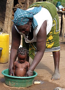 Fare il bagno a un bambino in Mozambico.