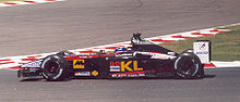 Mark Webber mengemudikan Minardi PS02 di Grand Prix Prancis 2002.