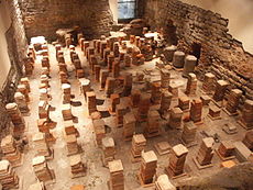 Caldarium från de romerska baden i Bath, England. Golvet har avlägsnats för att avslöja pelarna till förbränningsugnen.  