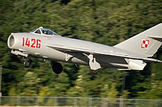 En sølvfarvet MiG-17 på vej op.  