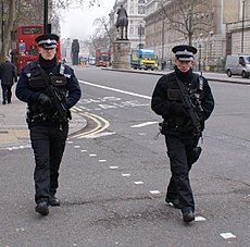 Puolustusministeriön poliiseja MP7-aseiden kanssa partioimassa Lontoon keskustassa.  