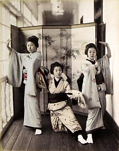 Tre maikos che mostrano i loro kimono e obis ricamati.