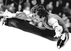 Cranston maakt een split jump tijdens de wereldkampioenschappen kunstschaatsen in 1974