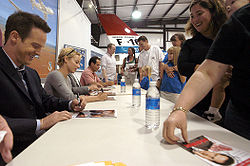 Skådespelarna skriver autografer efter att ha filmat en av showerna.