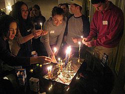 Membros da DC Minyan light Hanukkah candles