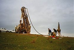 A mobile drilling rig on a truck is used to drill the first test wells in a new area of acreage. In this case, only crushed rock samples ("chips") are obtained instead of the (expensive) drill cores. At the "cyclone" (right in the picture) they are examined and packed.
