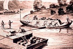 Un barco plano pasa por delante de un largo barco de quilla en forma de cigarro en el río Ohio.  