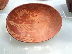 王朝時代前期に作られた皿です。舟に乗った男とカバ、ワニが描かれています。