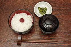 Een typisch Japanse maaltijd: eetstokjes op een eetstokjessteun aan de voorkant van de borden, wijzend naar links