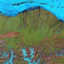 Fałszywy kolorowy obraz zbocza północnego z satelity Landsat 7. Niebieskie części to lód. Brooks Range jest widoczny na dole. (czerwiec 2001)
